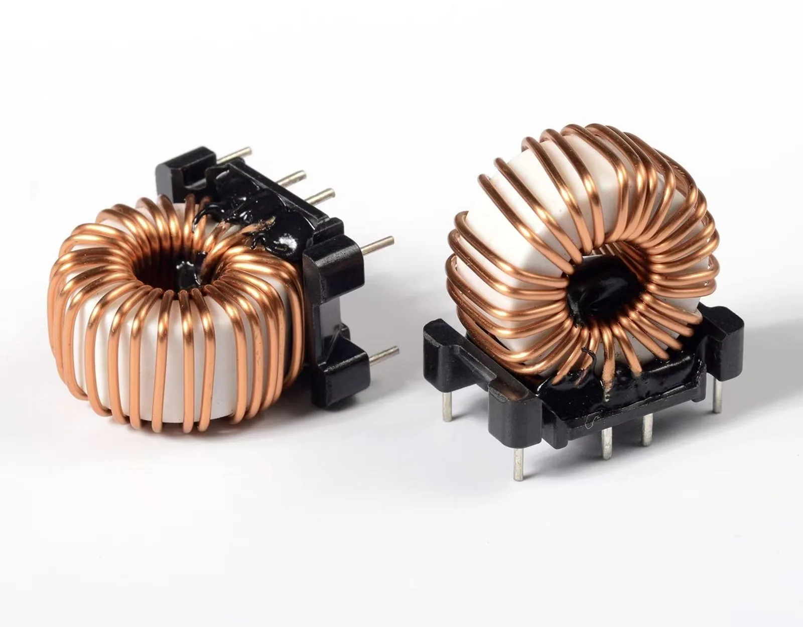 Two toroidal common-mode chokes with copper windings mounted on black plastic bases
