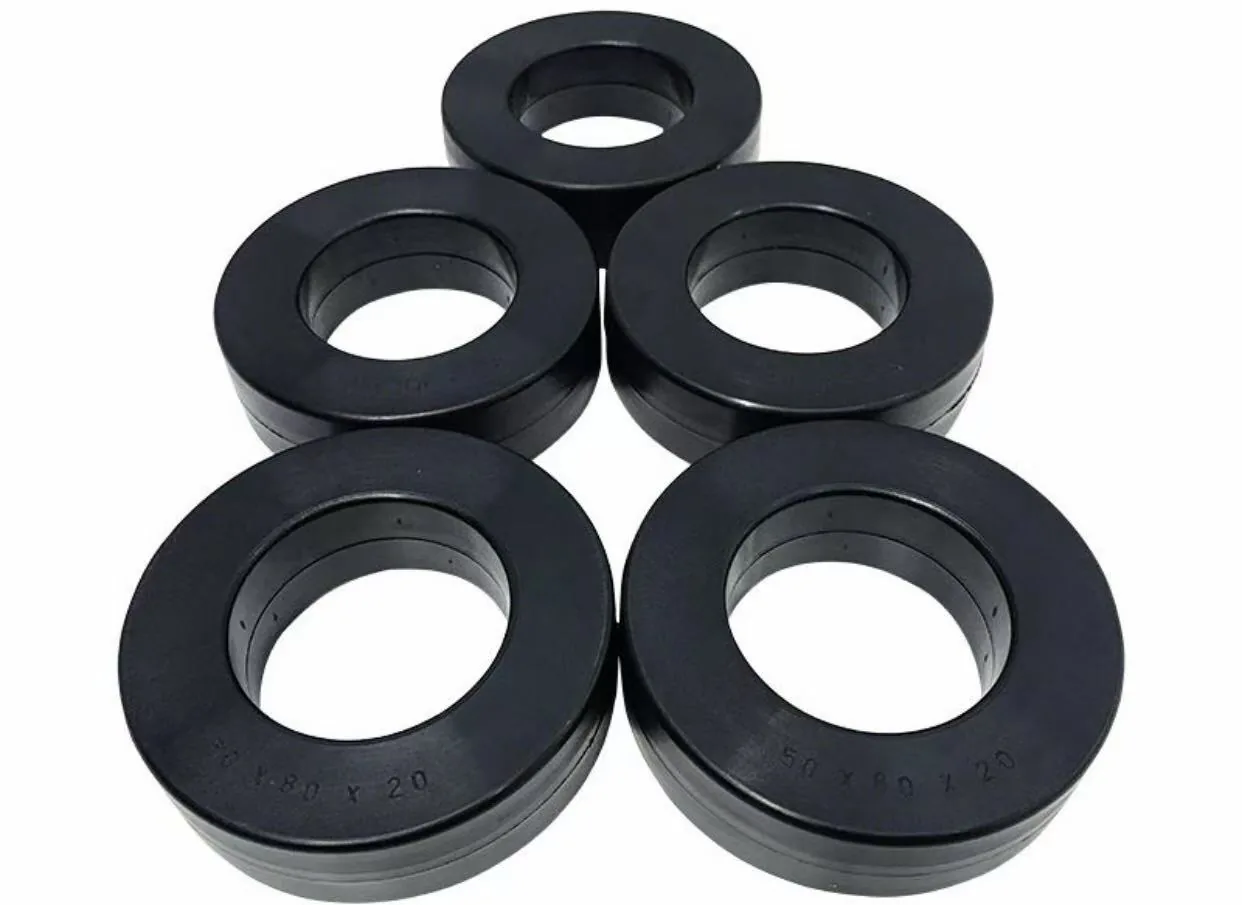 Five black coated toroidal magnetic cores arranged on a white background